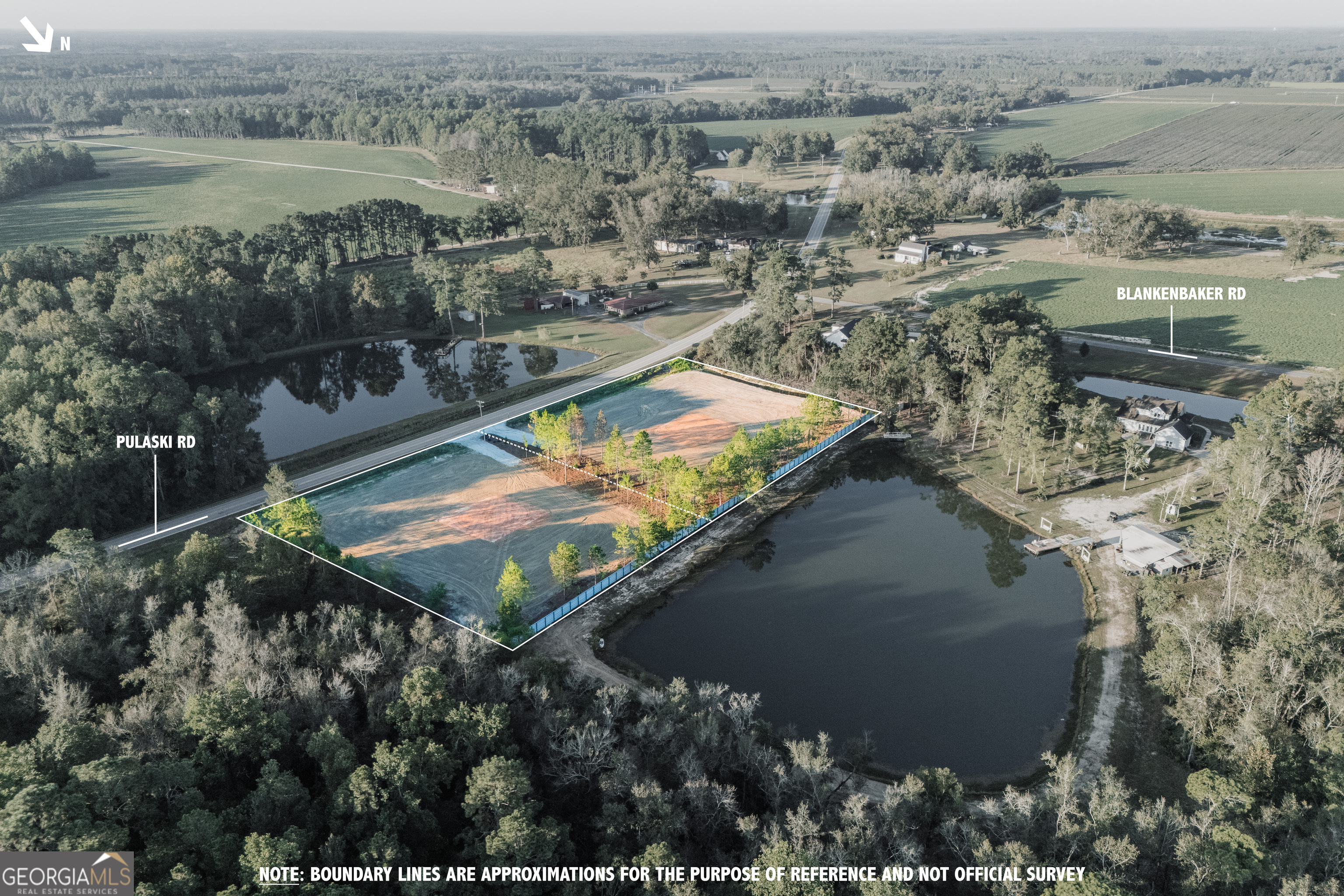 an aerial view of residential houses with outdoor space and lake view