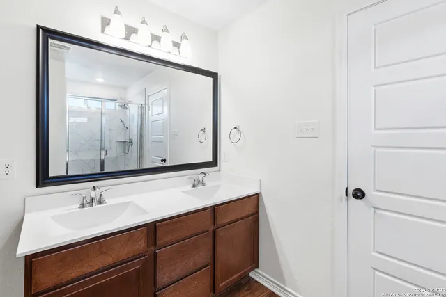 a bathroom with a double vanity sink and a mirror