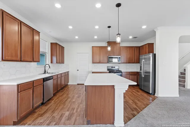 a large kitchen with stainless steel appliances kitchen island a large counter space a sink appliances and cabinets