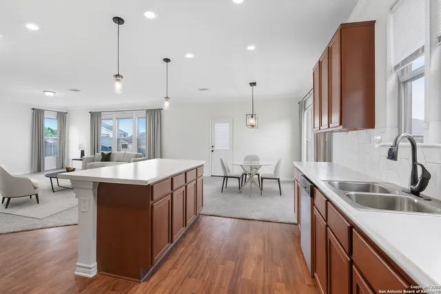 an open kitchen with stainless steel appliances granite countertop a sink a stove and a wooden floors