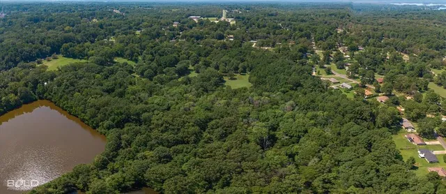 an aerial view of a house with a yard and lake view