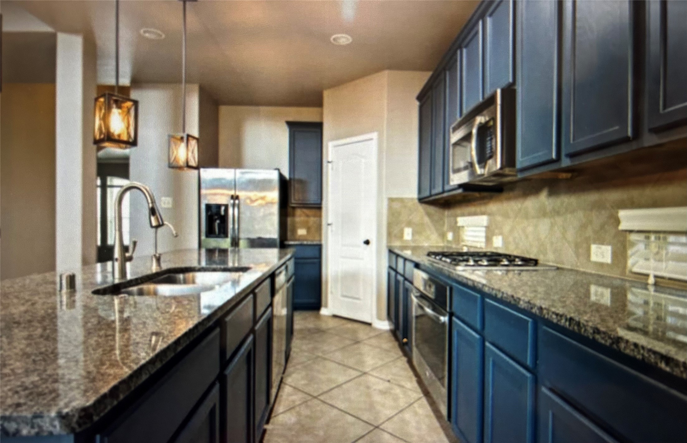 7936 Lake Commons Drive Rosenberg, TX 77469 - Photo 15 of 34 a kitchen with stainless steel appliances granite countertop a sink a stove and a refrigerator