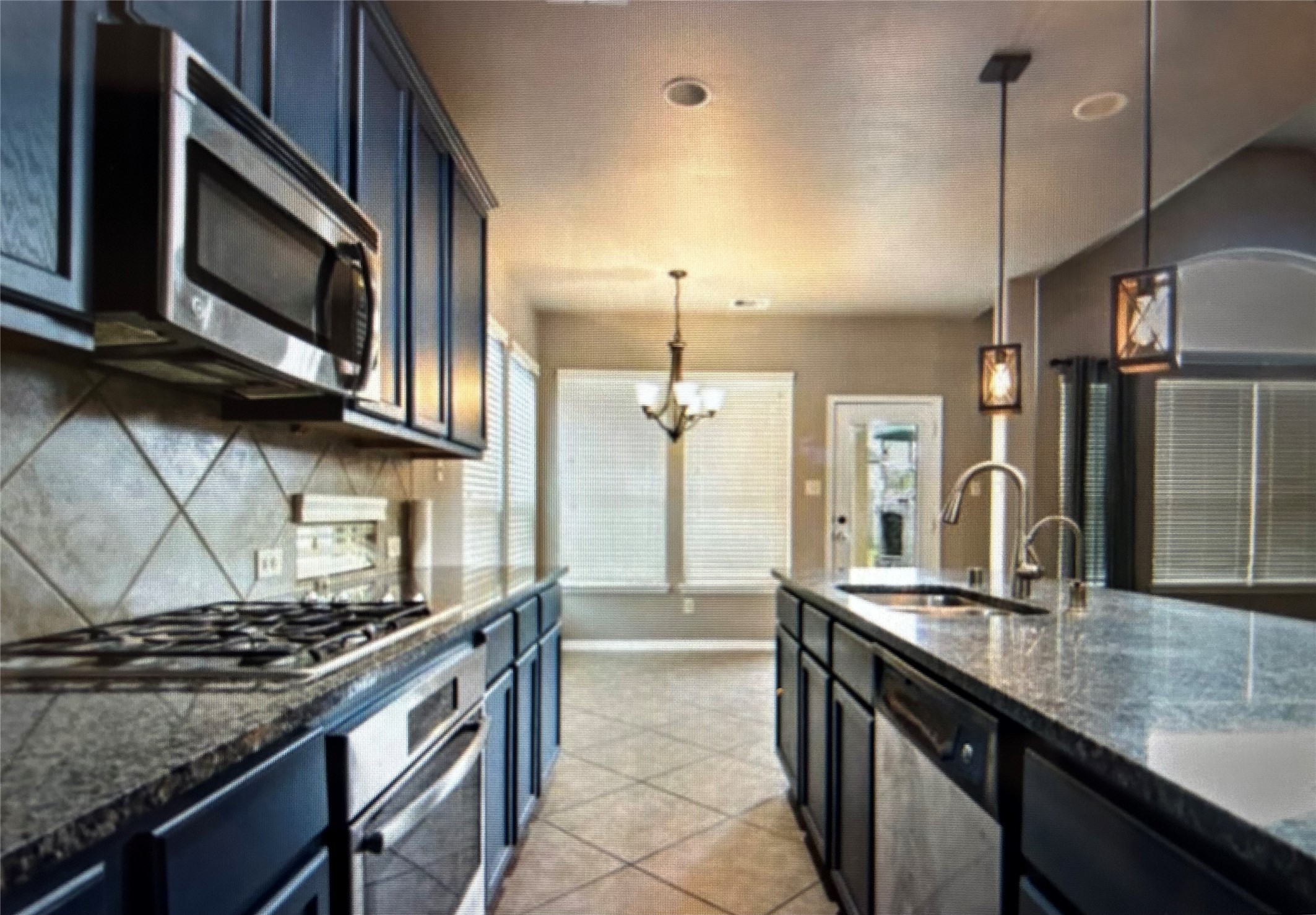 7936 Lake Commons Drive Rosenberg, TX 77469 - Photo 17 of 34 a kitchen with stainless steel appliances granite countertop a stove a sink and a microwave