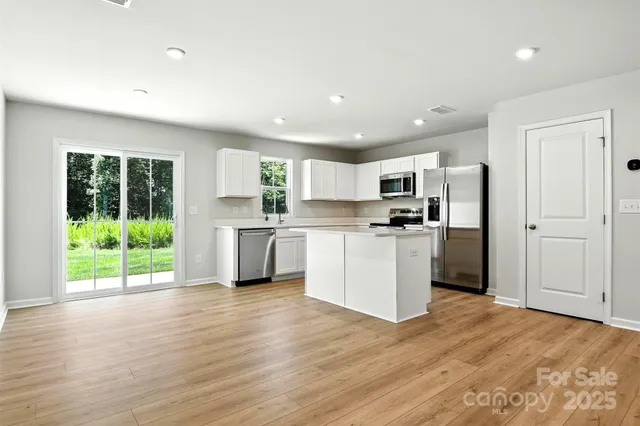 a kitchen with a refrigerator a stove top oven a sink and cabinets