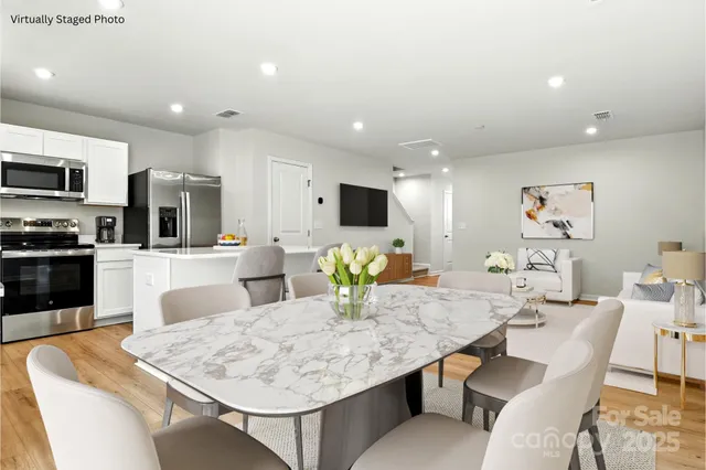 a view of a white house with couches chairs and wooden fence