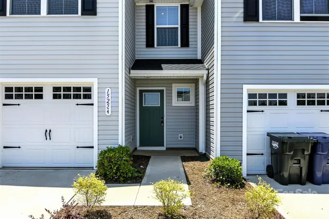 a view of a hallway with wooden floor and a bathroom