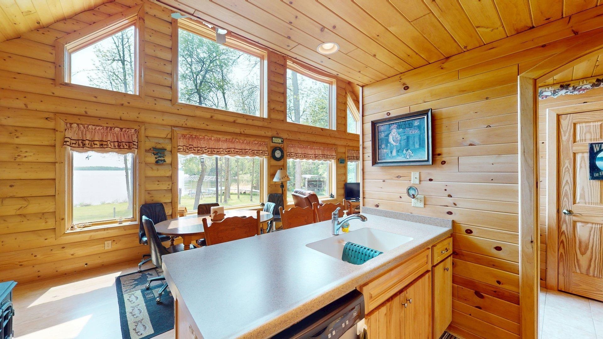 10898 Bessette Road Orr, MN 55771 - Photo 21 of 49 Kitchen with a sink, wooden ceiling, log walls, high vaulted ceiling, and stainless steel dishwasher