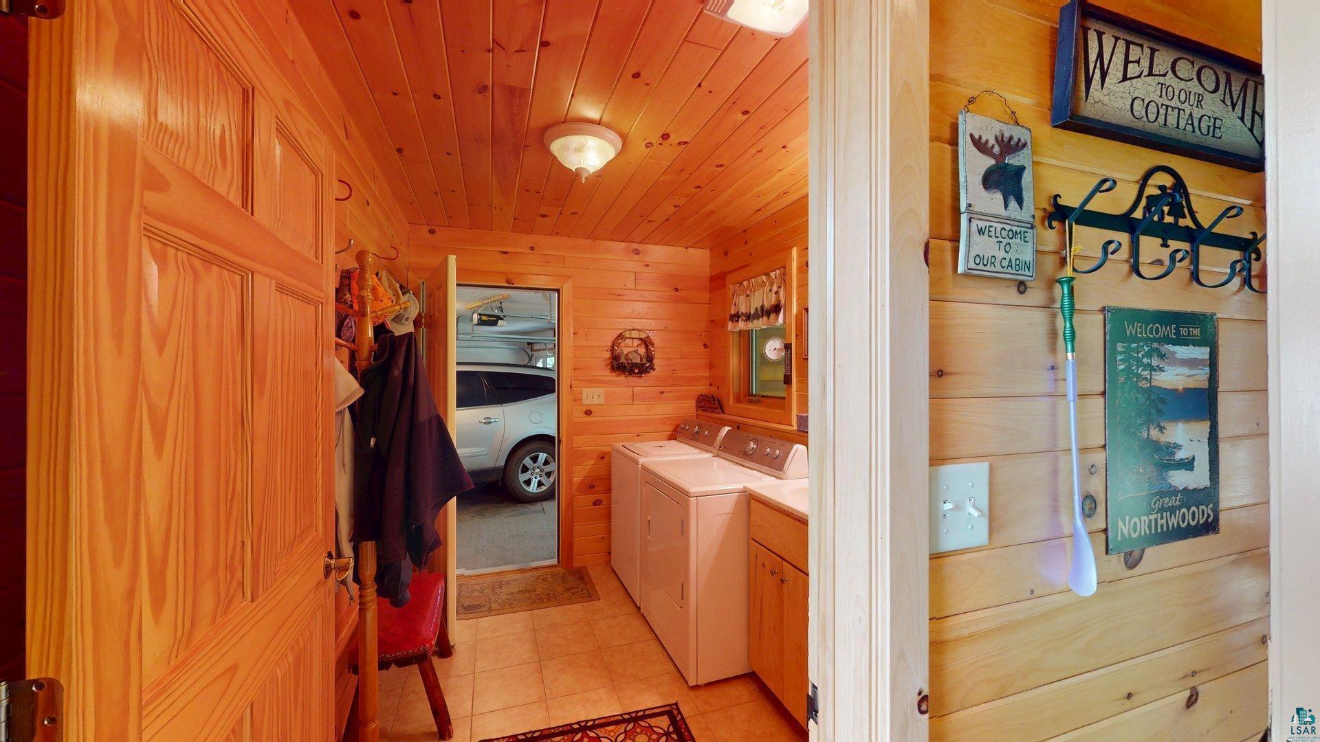10898 Bessette Road Orr, MN 55771 - Photo 23 of 49 Bathroom with wood ceiling, independent washer and dryer, wooden walls, vanity, and tile patterned floors