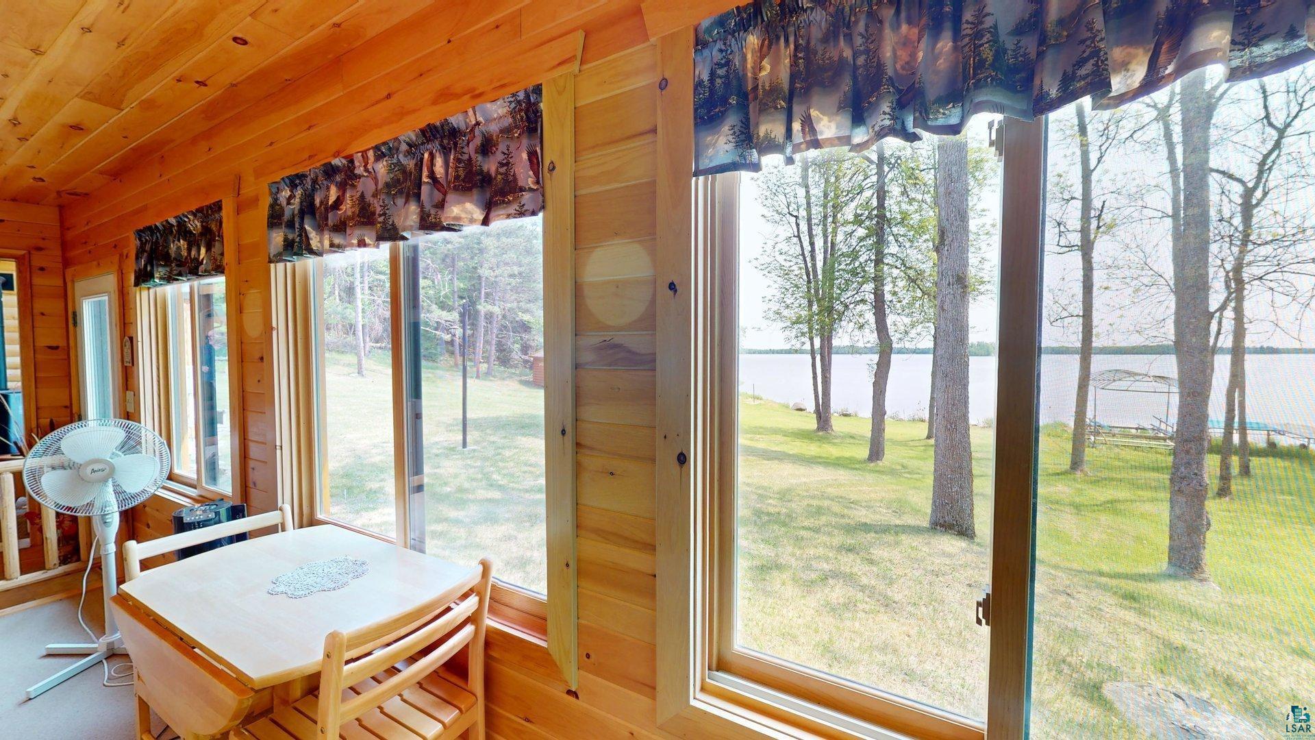 10898 Bessette Road Orr, MN 55771 - Photo 26 of 49 Sunroom featuring a water view, wooden walls, and wood finished floors