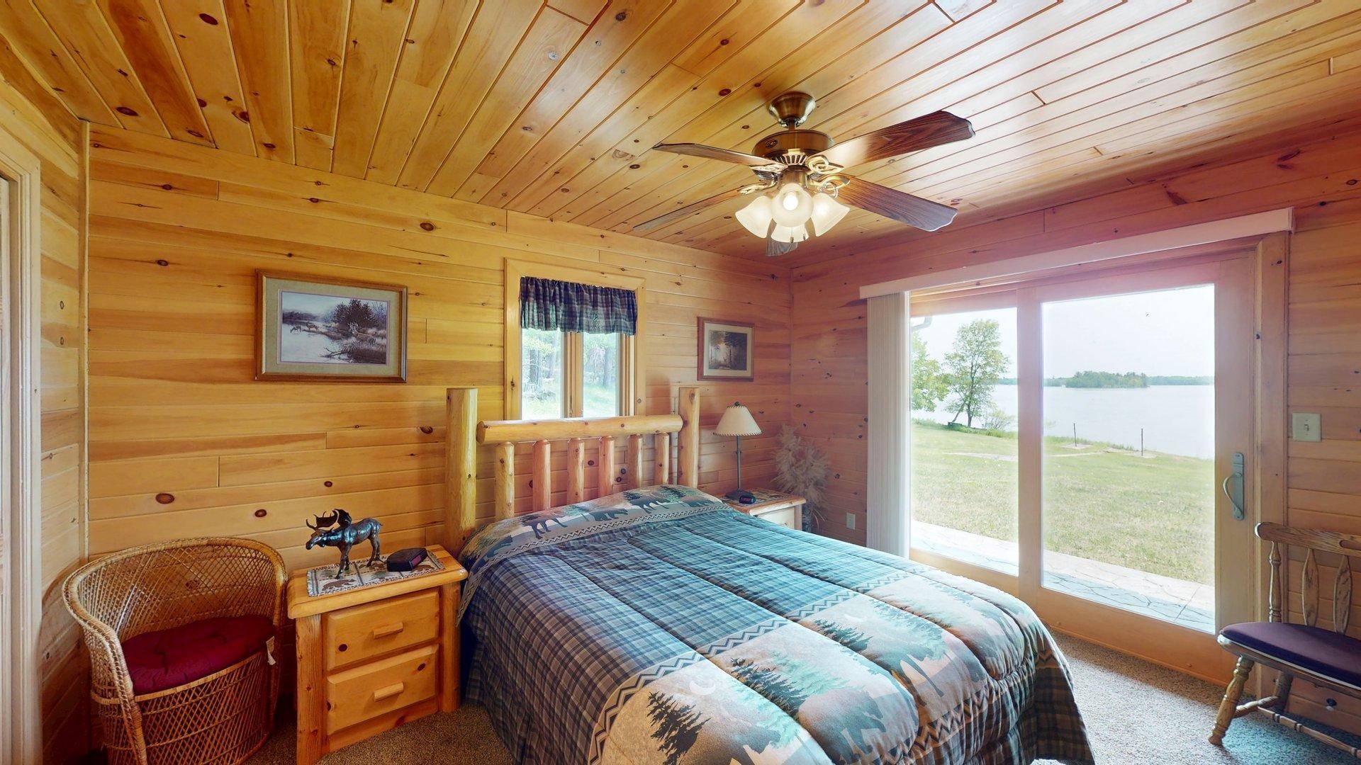 10898 Bessette Road Orr, MN 55771 - Photo 28 of 49 Bedroom with access to outside, carpet floors, wood ceiling, wooden walls, and a water view