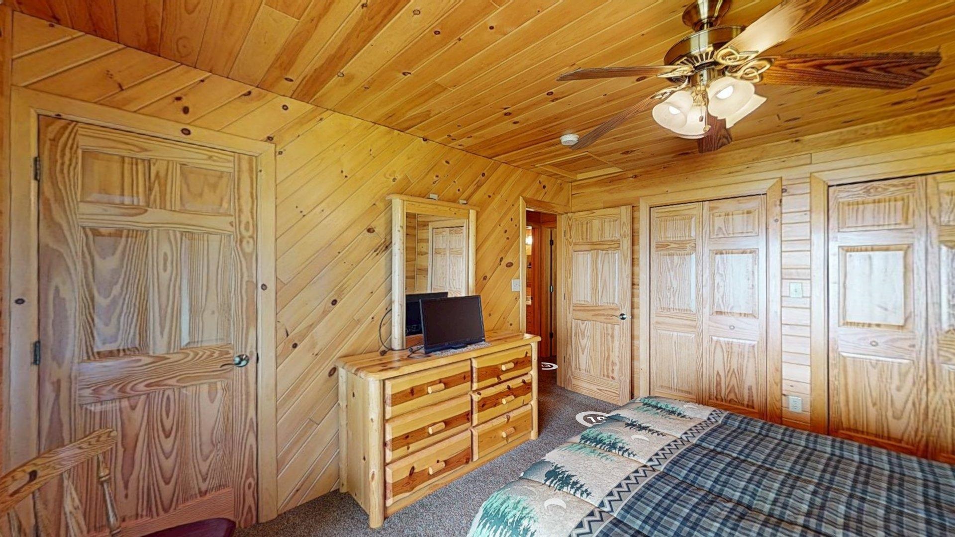 10898 Bessette Road Orr, MN 55771 - Photo 29 of 49 Bedroom with dark colored carpet, wooden ceiling, wood walls, and ceiling fan