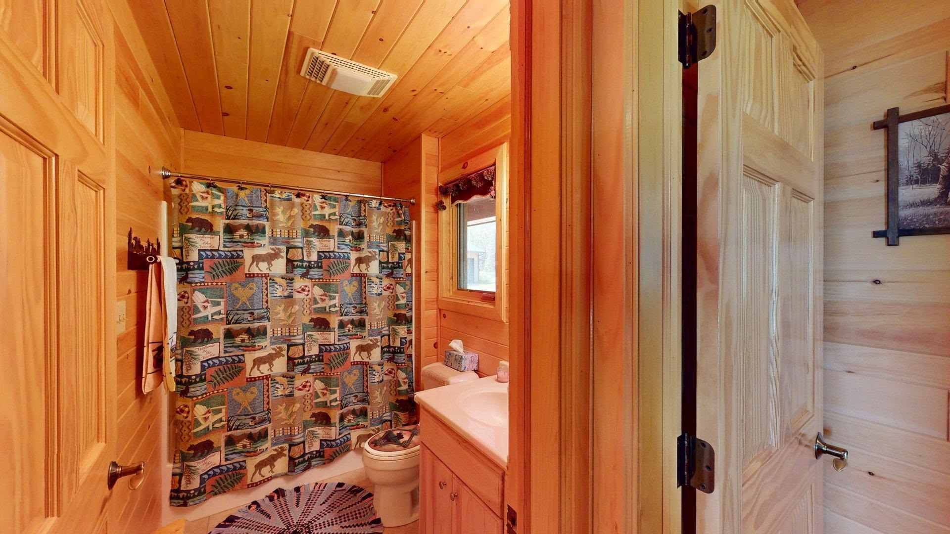 10898 Bessette Road Orr, MN 55771 - Photo 30 of 49 Full bath with wooden walls, vanity, toilet, wood ceiling, and a shower with shower curtain