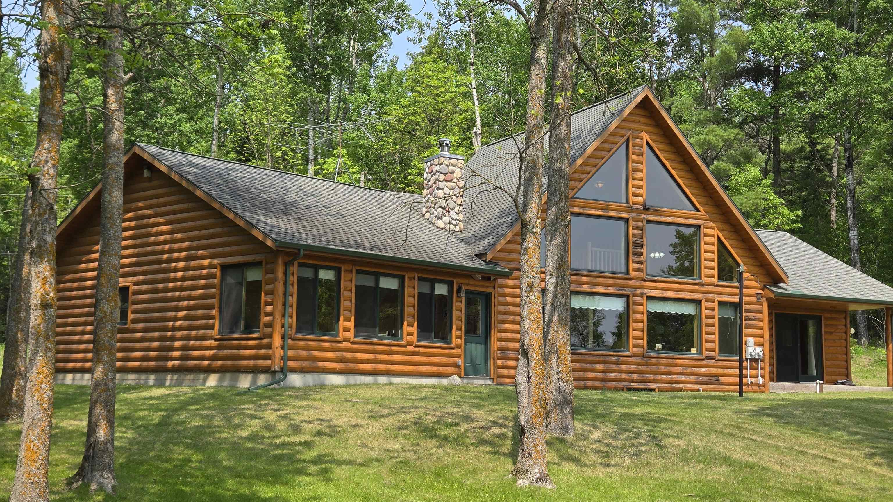 10898 Bessette Road Orr, MN 55771 - Photo 3 of 49 View of front facade featuring a chimney, a front yard, and a shingled roof