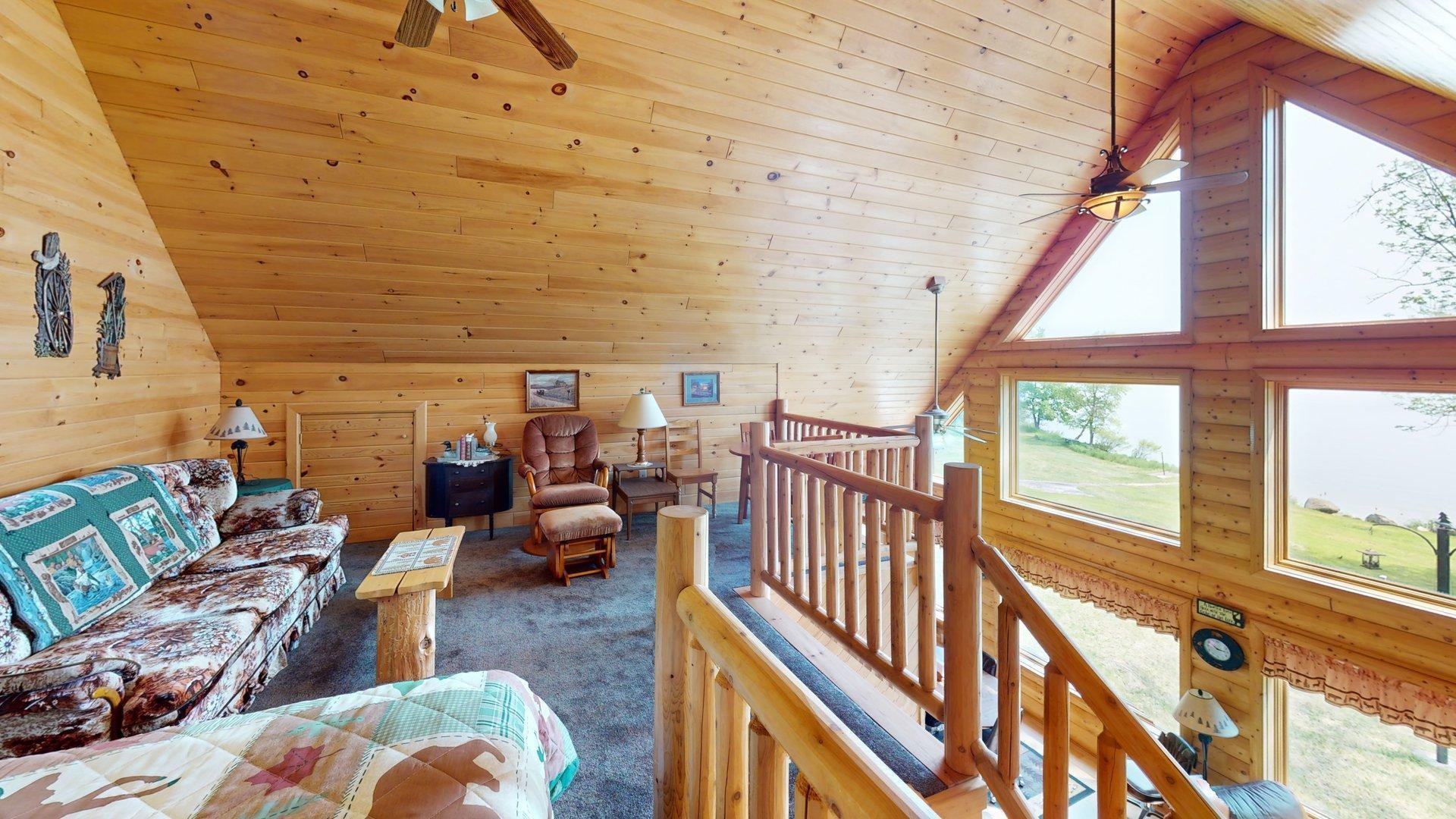 10898 Bessette Road Orr, MN 55771 - Photo 34 of 49 Carpeted living room with wood ceiling, a ceiling fan, wooden walls, and high vaulted ceiling