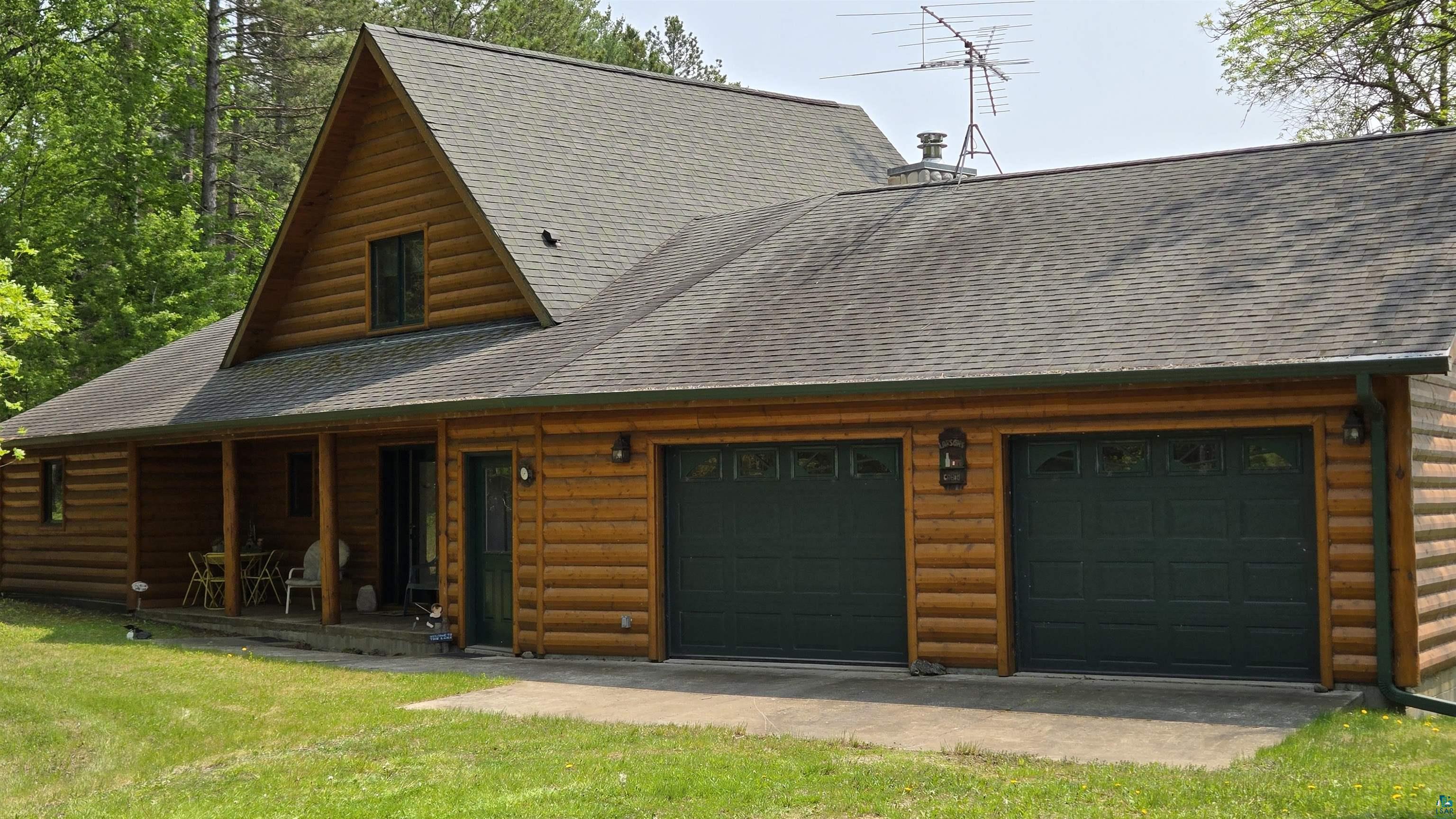 10898 Bessette Road Orr, MN 55771 - Photo 4 of 49 View of side of property with roof with shingles, a garage, and log veneer siding
