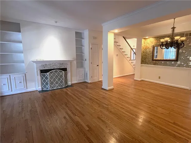 a view of a livingroom with wooden floor and a fireplace