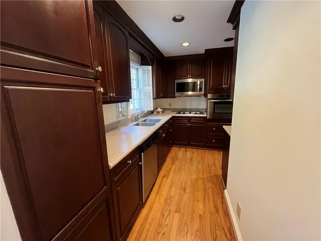a kitchen with kitchen island a counter top space a sink a refrigerator and cabinets