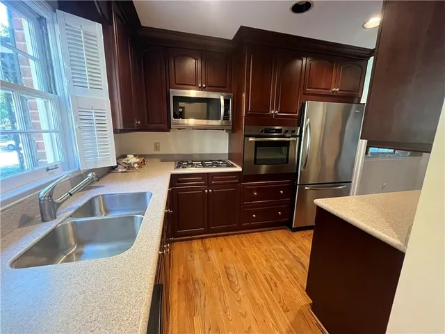 a kitchen with stainless steel appliances a refrigerator sink and microwave
