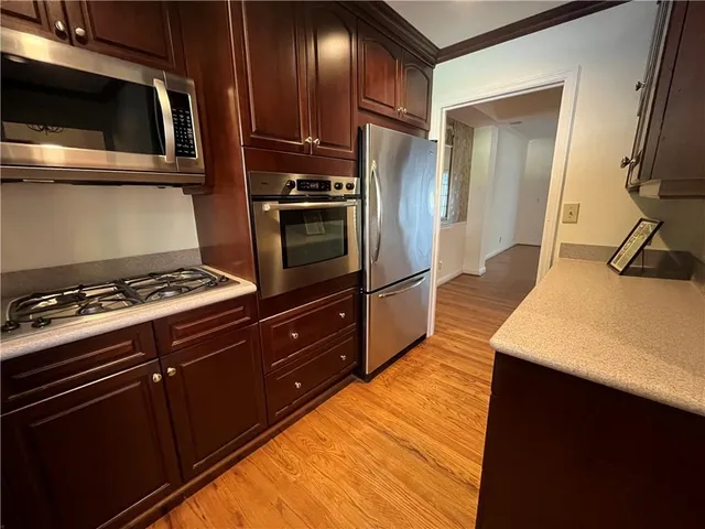 a kitchen with wooden cabinets and stainless steel appliances