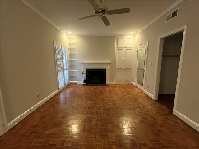 an empty room with windows and fireplace
