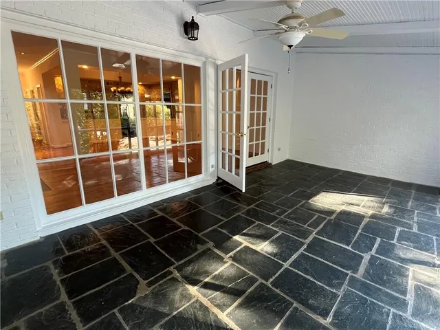 a view of an empty room with wooden floor and windows
