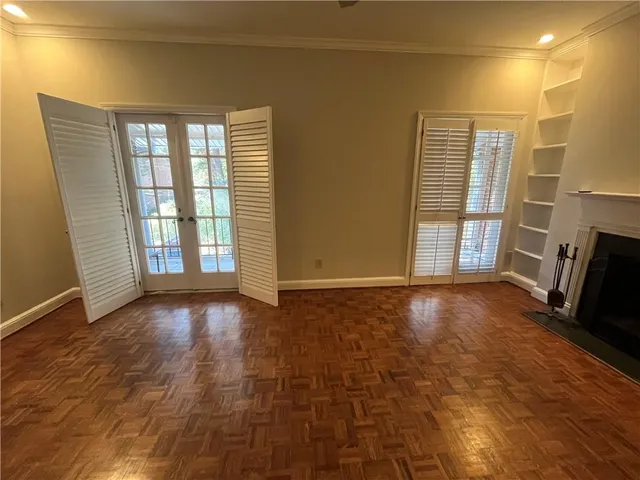 a view of an empty room with a fireplace and a window