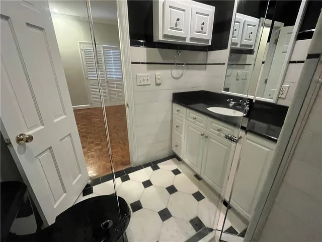 a bathroom with a sink and mirror with bathtub