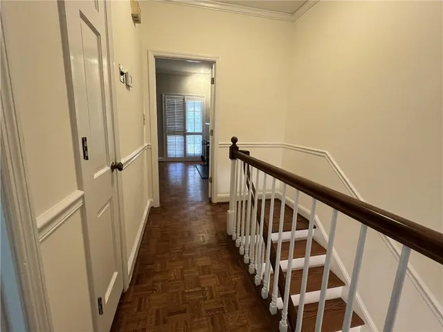 a view of a hallway with wooden floor and staircase