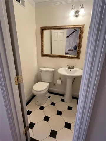 a bathroom with a sink a toilet a mirror and shower curtain