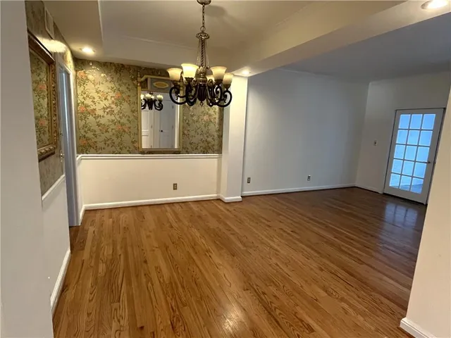 a view of a room with wooden floor and chandelier