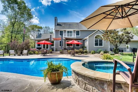 a patio with a table and chairs under an umbrella