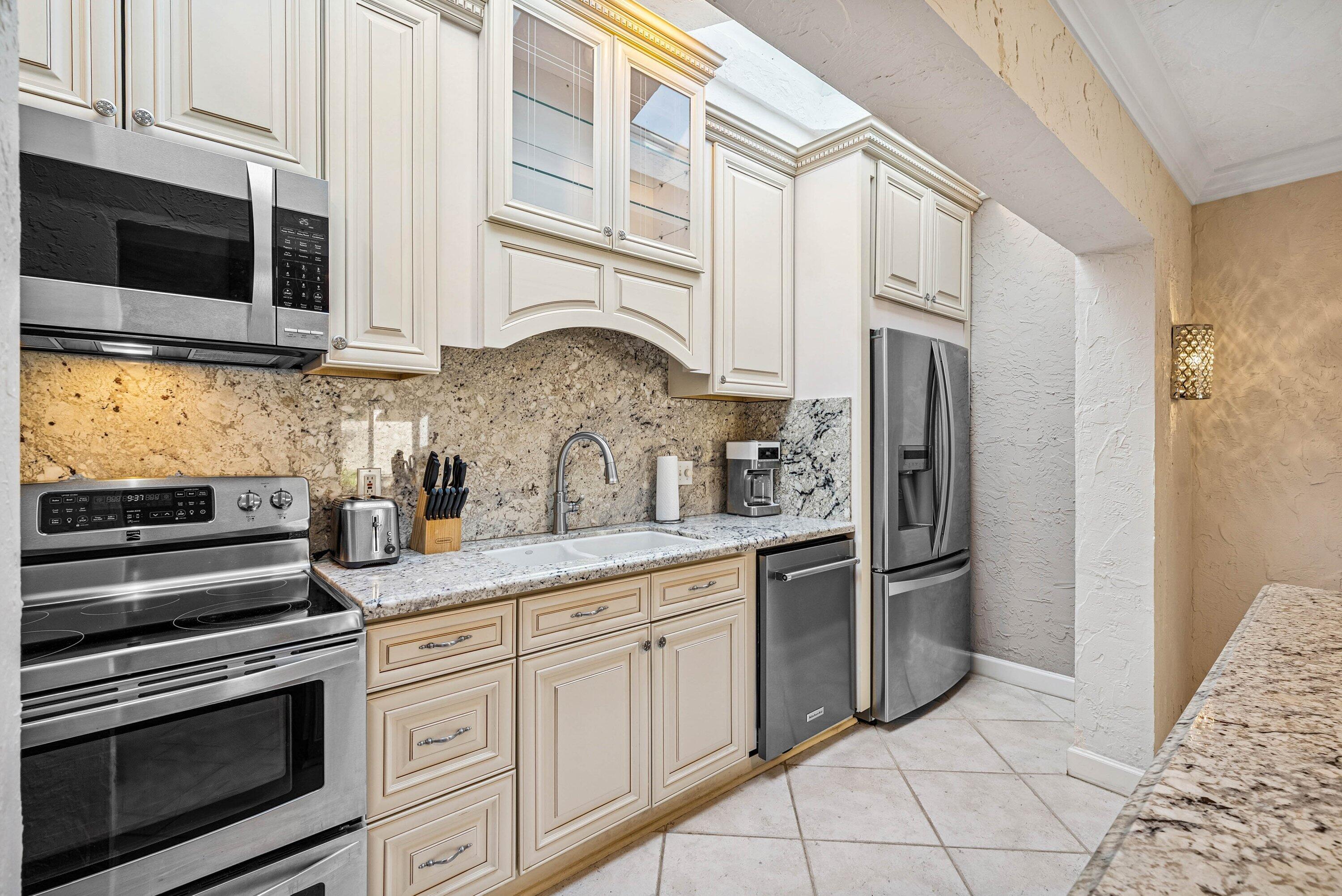 5926 Patio Drive Boca Raton, FL 33433 - Photo 11 of 33 a kitchen with stainless steel appliances granite countertop a refrigerator and a stove top oven