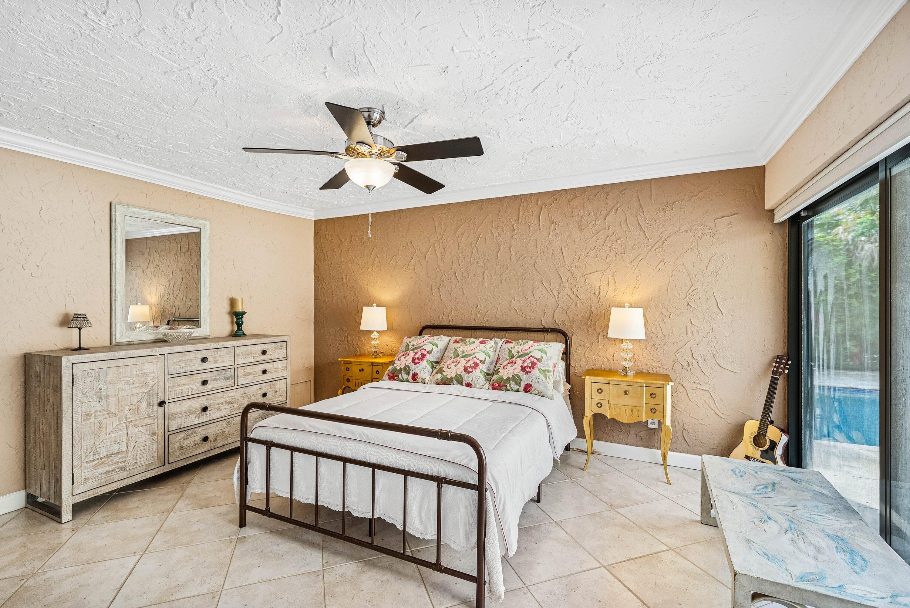 5926 Patio Drive Boca Raton, FL 33433 - Photo 17 of 33 a bedroom with a large bed and a chandelier fan