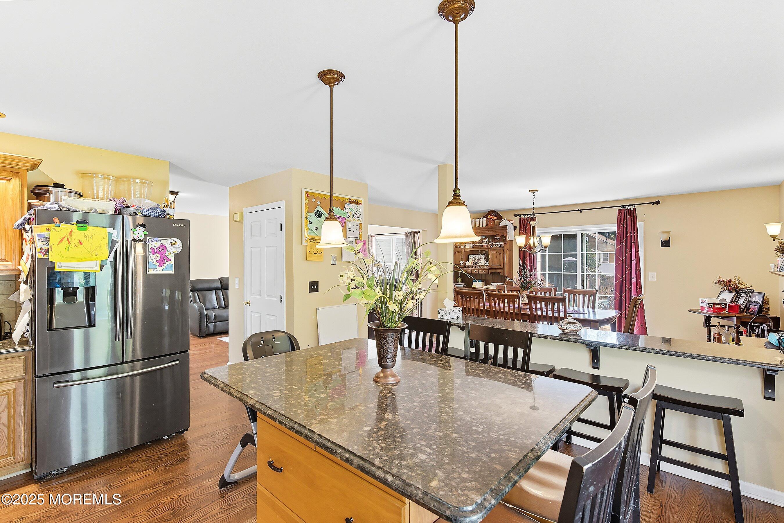 1090 Bennetts Mills Road Jackson, NJ 08527 - Photo 10 of 25 a kitchen with stainless steel appliances granite countertop a table chairs in it and wooden floors