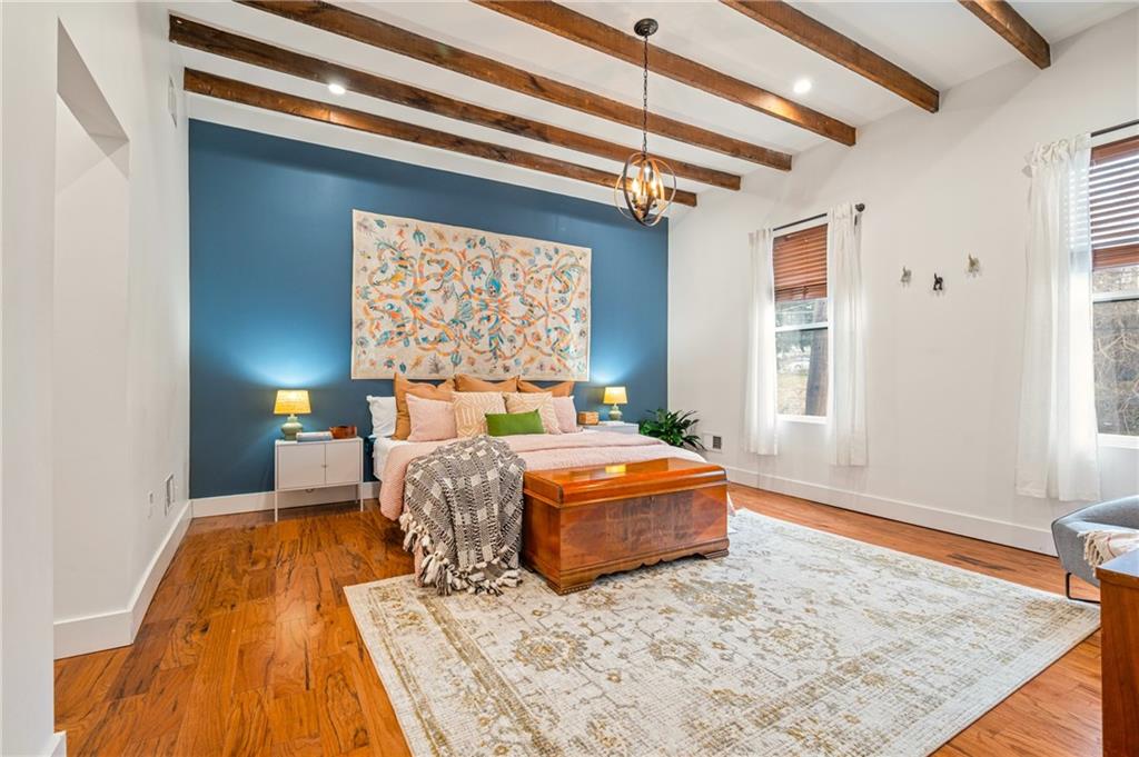 342 Harmar Street Pittsburgh, PA 15219 - Photo 12 of 30 A true primary retreat featuring exposed ceiling beams, warm hardwood floors, and a dramatic accent wall.