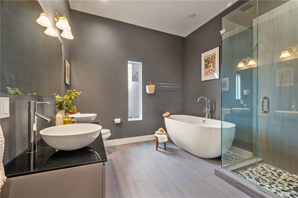 342 Harmar Street Pittsburgh, PA 15219 - Photo 16 of 30 Spa-level primary bath with freestanding soaking tub, glass-enclosed shower, dual vessel sinks, and modern tile work.