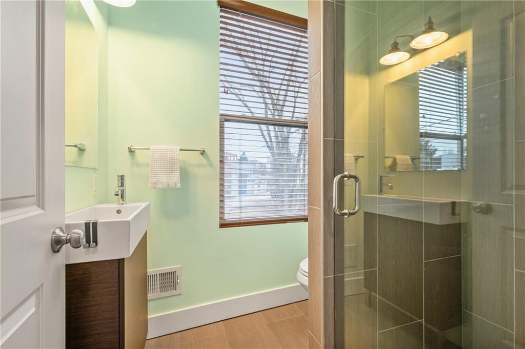 342 Harmar Street Pittsburgh, PA 15219 - Photo 20 of 30 Light-filled full bath with glass shower enclosure and soft green walls, fresh, clean, and quietly modern.