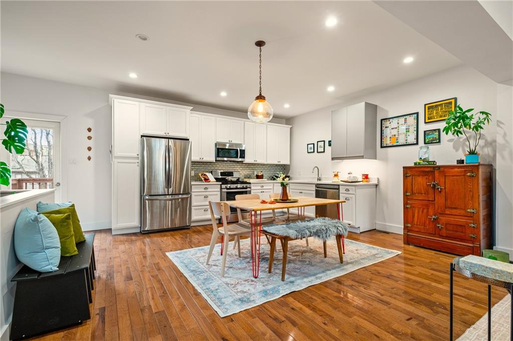 342 Harmar Street Pittsburgh, PA 15219 - Photo 6 of 30 Generous dining zone centered beneath a statement globe pendant, perfectly scaled for both weeknight dinners and full-table gatherings.