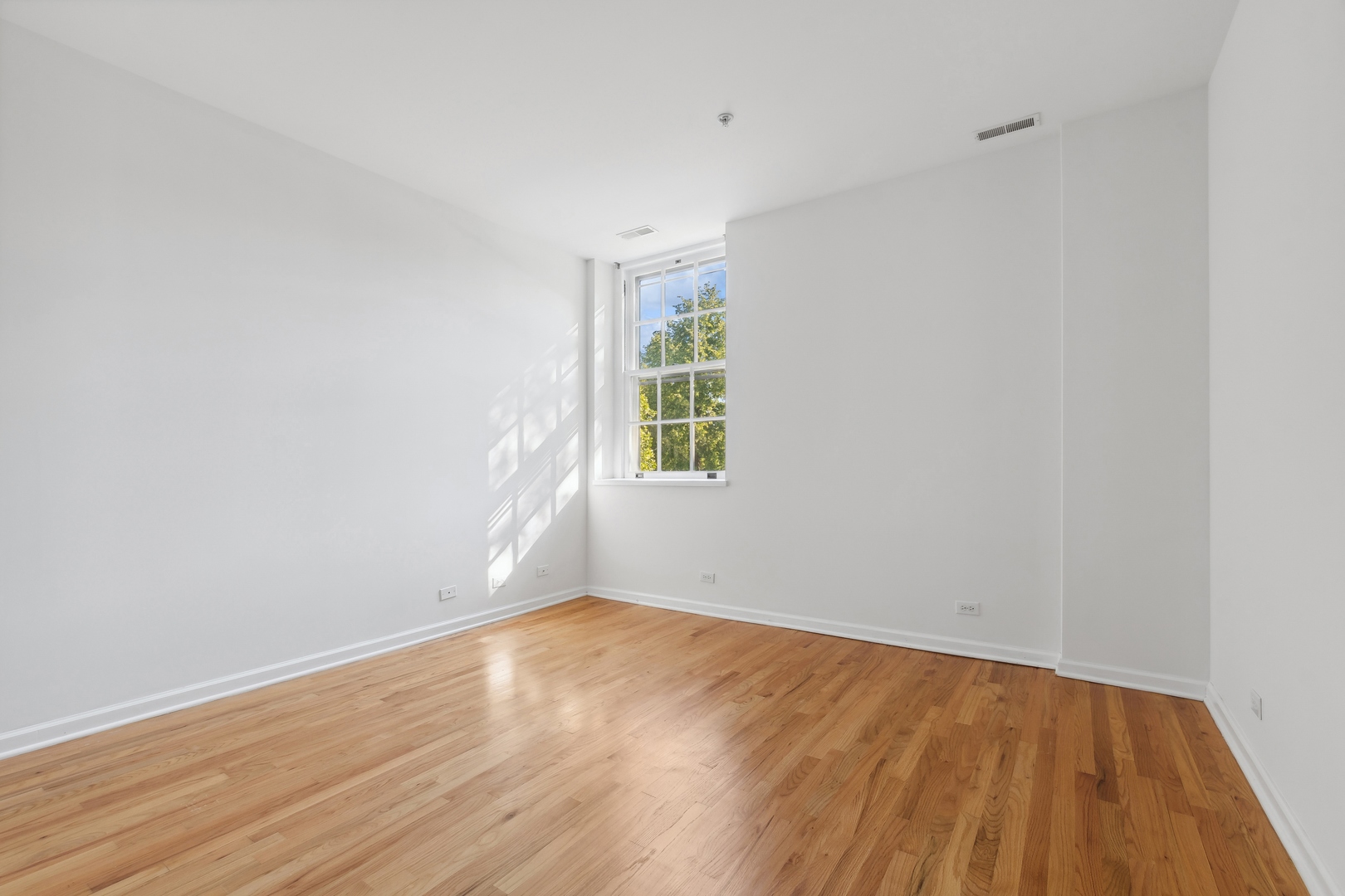 25 Ronan Road, Unit 106 Highwood, IL 60040 - Photo 8 of 14 a view of an empty room with wooden floor and a window