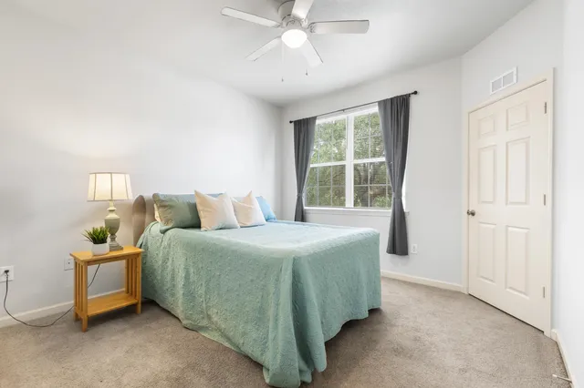 a spacious bedroom with a bed and a chandelier