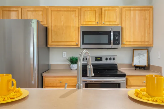 a kitchen with stainless steel appliances granite countertop a refrigerator and a stove top oven