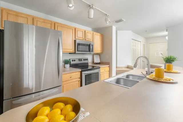 a kitchen with sink a refrigerator and a stove top oven