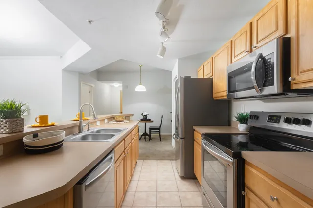 a kitchen with stainless steel appliances a sink a stove and a refrigerator