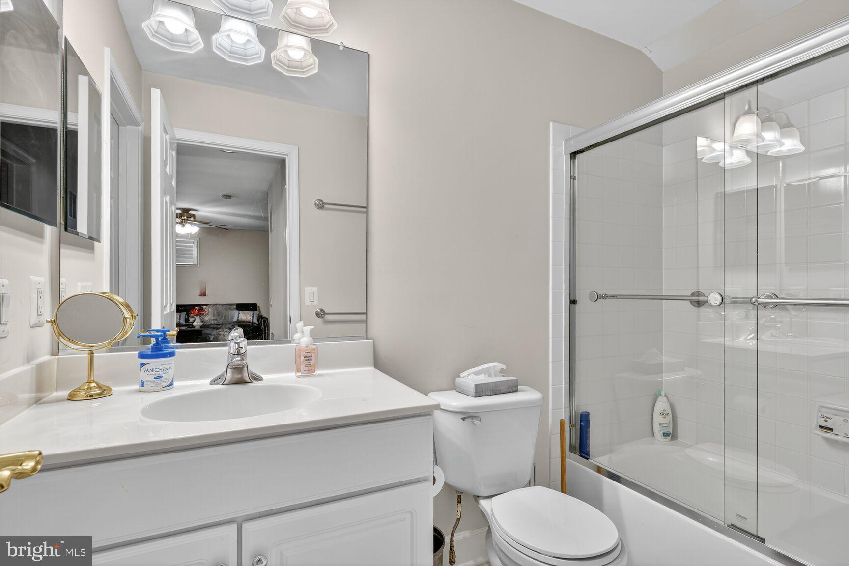 8912 Yellow Daisy Place Lorton, VA 22079 - Photo 13 of 24 a bathroom with a sink toilet a mirror and shower