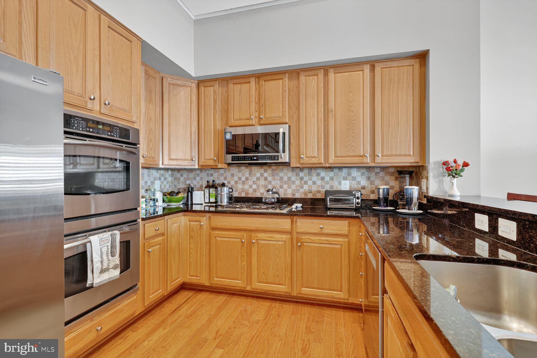 8912 Yellow Daisy Place Lorton, VA 22079 - Photo 5 of 24 a kitchen with granite countertop a sink stainless steel appliances and cabinets