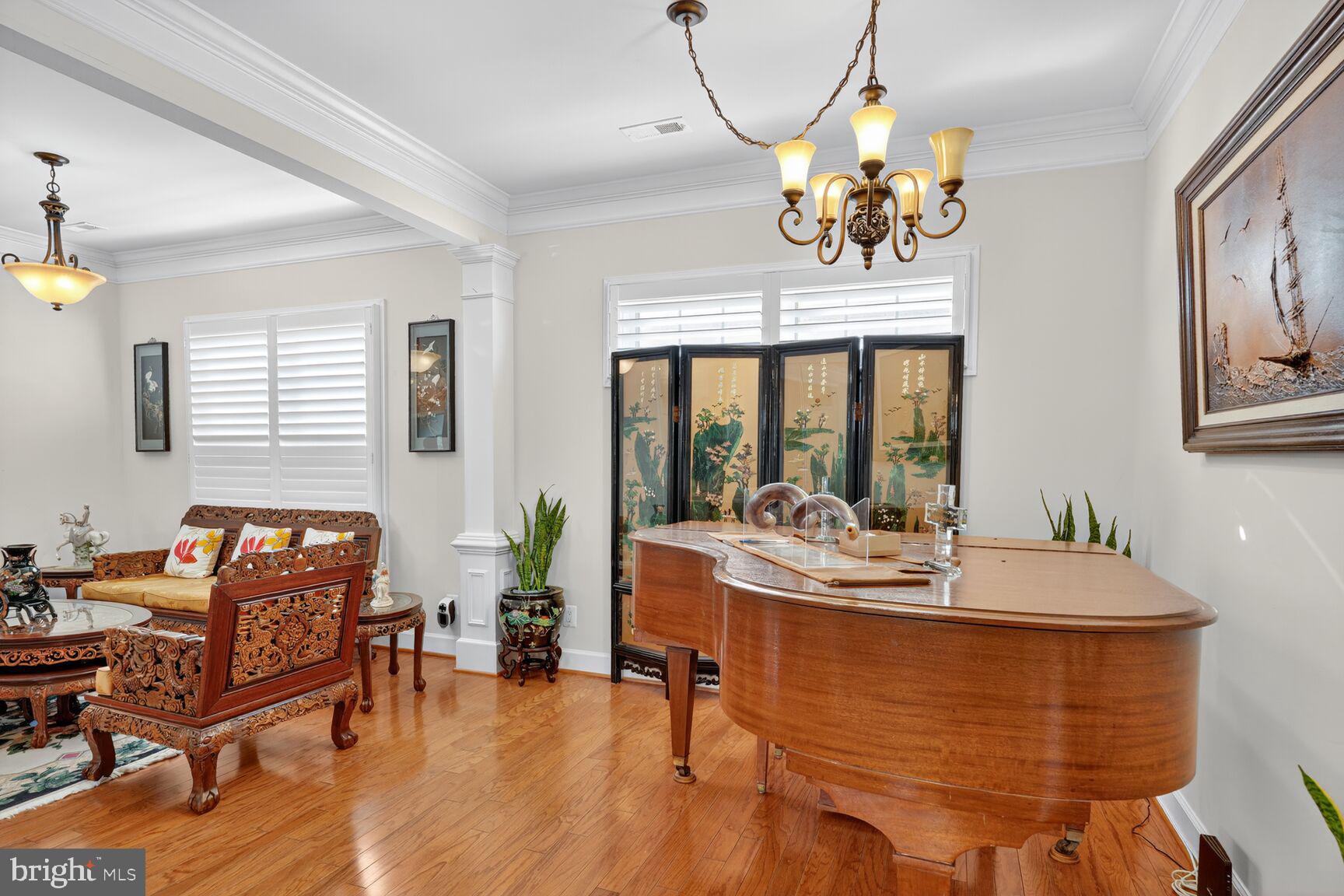8912 Yellow Daisy Place Lorton, VA 22079 - Photo 7 of 24 a dining room with wooden floor a chandelier a glass table and chairs