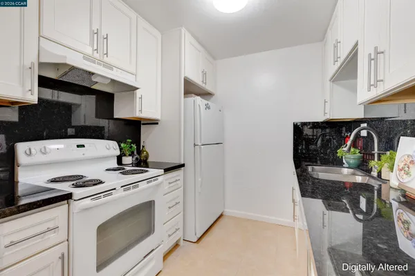 a kitchen with stainless steel appliances granite countertop a refrigerator and a stove