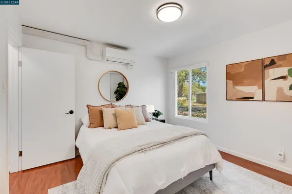 a bedroom with a bed and a lamp on dresser