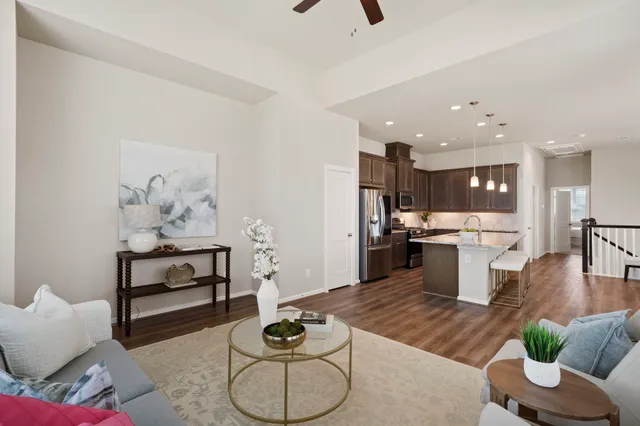 a kitchen with granite countertop kitchen island stainless steel appliances sink refrigerator dining table and chairs