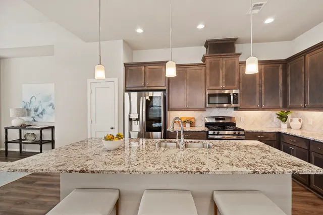 a kitchen with refrigerator and wooden floor